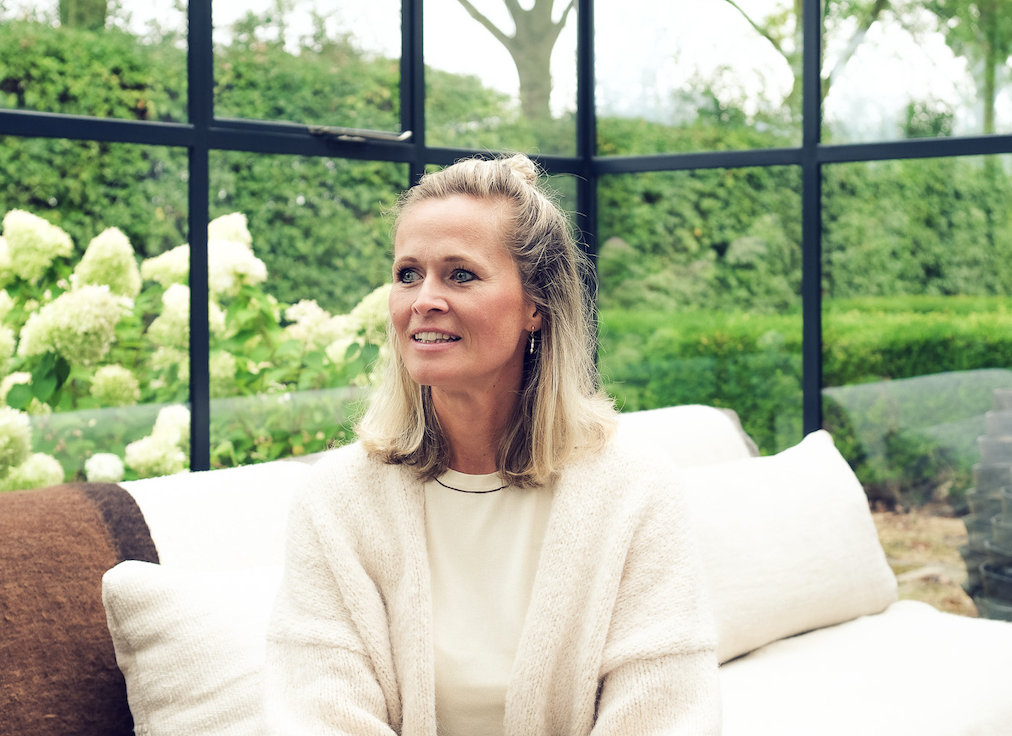 Vrouw kijkt weg in een serre met een groene achtergrond